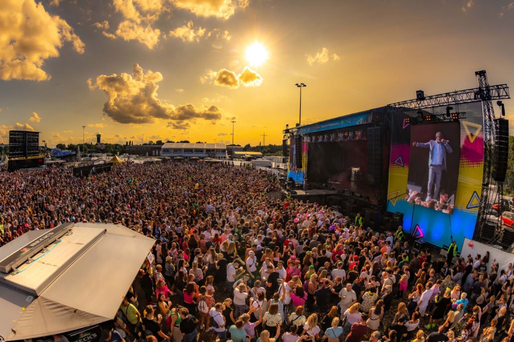 Open-Air-Festival mit tausenden Besuchern bei Sonnenuntergang